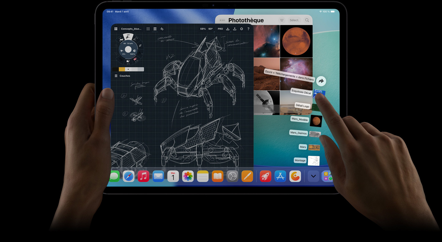 iPad Pro, face avant, orientation paysage, main droite manipulant les fichiers du dossier Téléchargements en éventail, écran affichant l’interface iPadOS 26 avec plusieurs apps ouvertes, dont une app de retouche photo avec des plans détaillés de robots et des annotations manuscrites ainsi que plusieurs étapes de conception, et la photothèque