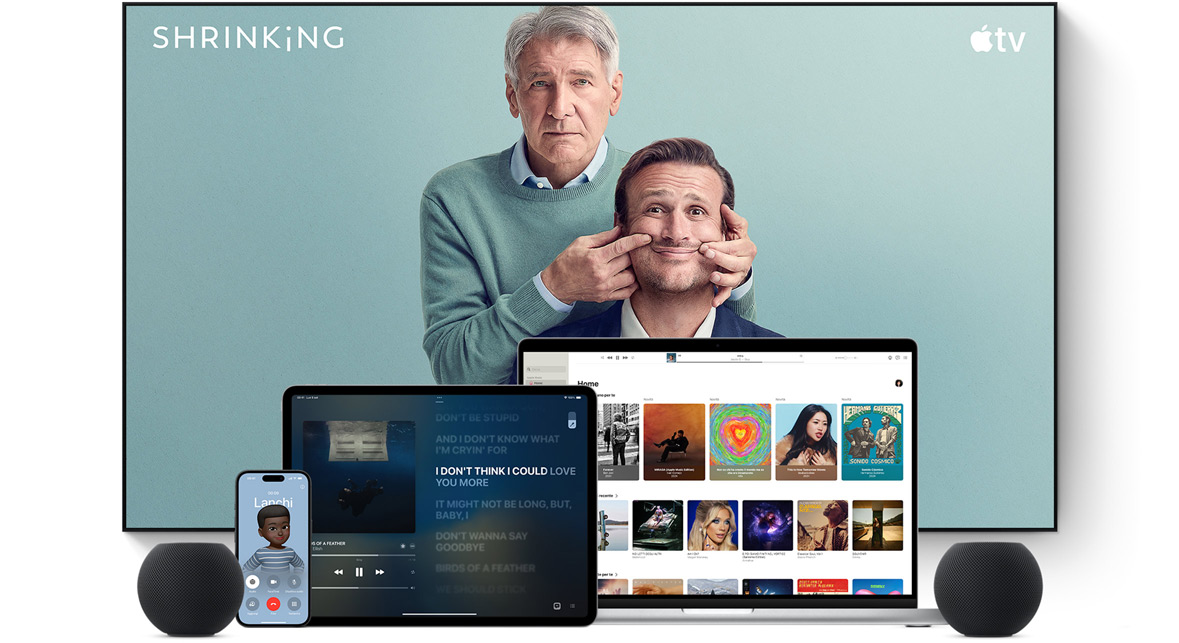 Large flat screen television showing two male characters from the Apple TV series shrinking. A MacBook Pro, an iPad, an iPhone, and a Midnight HomePod mini are arranged in front.