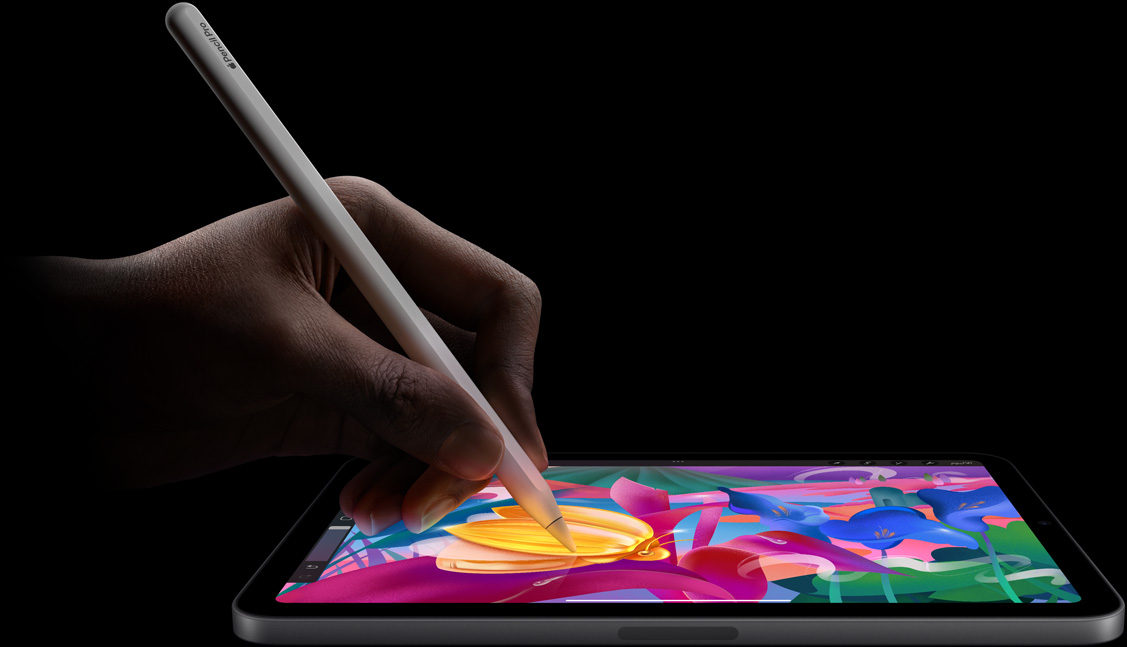 يد مستخدم تمسك بقلم Apple Pro وترسم أعمالاً فنية ملونة على iPad mini.