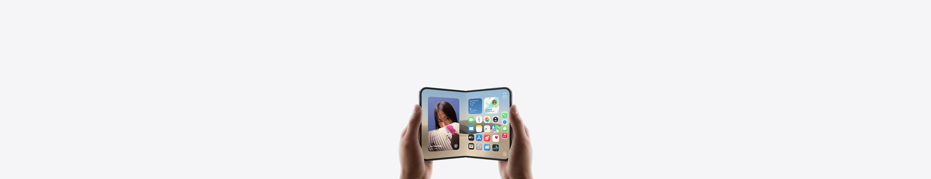 Dwa telefony iPhone Duo w układzie poziomym, trzymane w dwóch dłoniach, urządzenia są otwarte, na wewnętrznym wyświetlaczu widać ekran początkowy