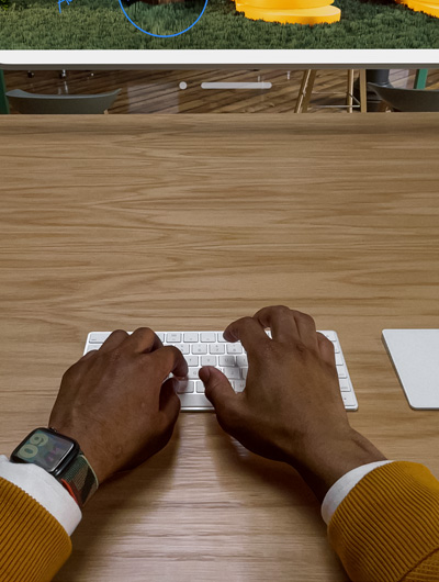 Deux mains posées sur un Magic Keyboard