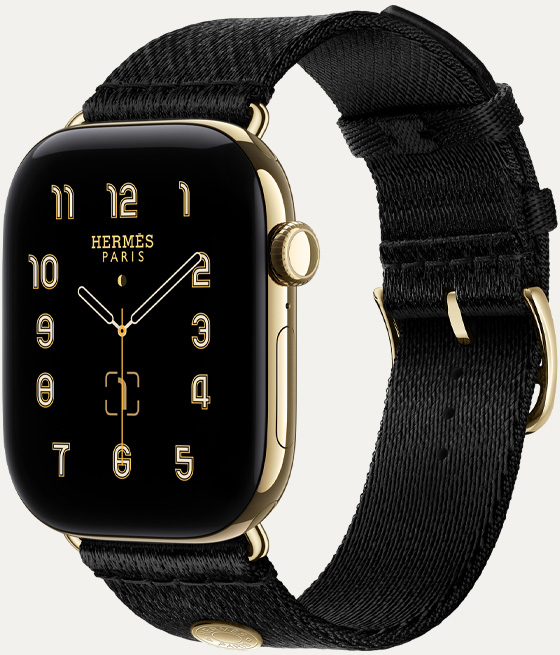 Apple Watch Hermès Series 12, Clou de Selle analogue watch face (hour, minute and second hands, complications: lunar phase, date), titanium case, radiant gold colour, right side exterior, Digital Crown, side button, paired with Noir Satin Clou de Selle band, smooth black satin webbing with radiant gold hardware that matches the watch case