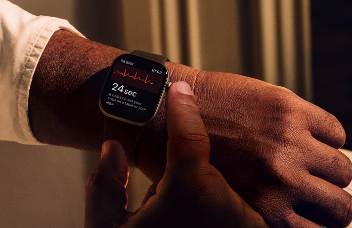 O persoană apasă lung pe Digital Crown pe Apple Watch Series 11 pentru a măsura sănătatea inimii în aplicația EKG