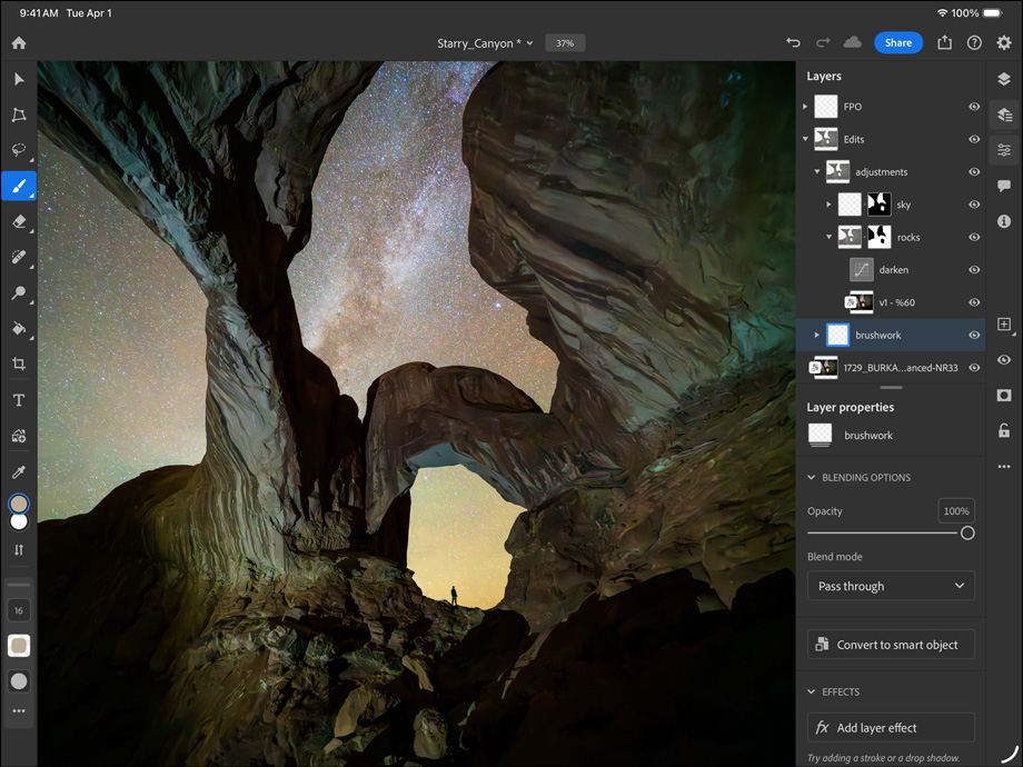 iPad Pro, front exterior, landscape orientation, space black color, rounded corners, black display bezel, display showing a photograph being edited of a canyon and a star filled night sky, at right, editing layers, tools, and effects visible including brushwork, adjustments, and others