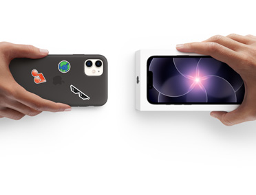 Una mano sostiene un iPhone 11 en una funda de silicón con stickers en la parte posterior y, al lado, una mano sostiene un nuevo iPhone 17e dentro de su caja para hacer el canje