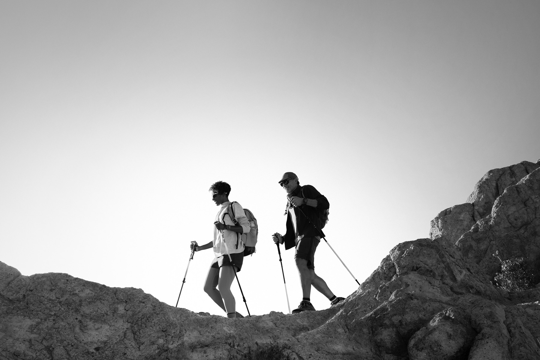 Two people wearing Apple Watch Ultra 3 hike a mountain trail